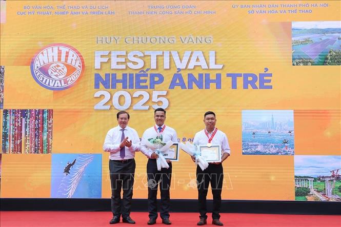 Thứ trưởng Bộ Văn hoá, Thể thao và Du lịch Tạ Quang Đông trao Huy chương vàng cho các nhiếp ảnh trẻ. Ảnh: Khánh Hoà - TTXVN