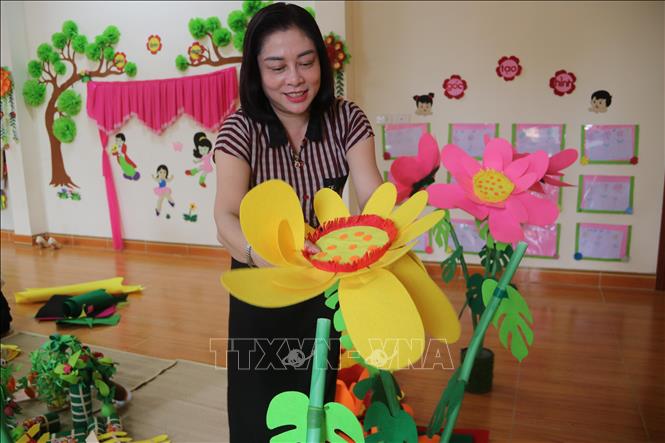 Cô Vũ Thị Ngát, Hiệu trưởng trường Mầm non Bùi Hữu Diên (xã Hồng Minh) làm đồ dùng dạy học trước thềm năm học mới. Ảnh: Thu Hoài - TTXVN