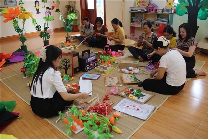 Giáo viên trường Mầm non Bùi Hữu Diên (xã Hồng Minh) làm đồ dùng dạy học. Ảnh: Thu Hoài - TTXVN