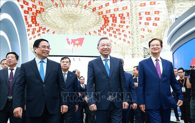 Tổng Bí thư Tô Lâm và Thủ tướng Phạm Minh Chính tham quan trưng bày thành tựu của đất nước tại Trung tâm Triển lãm Việt Nam. Ảnh: Dương Giang-TTXVN 
