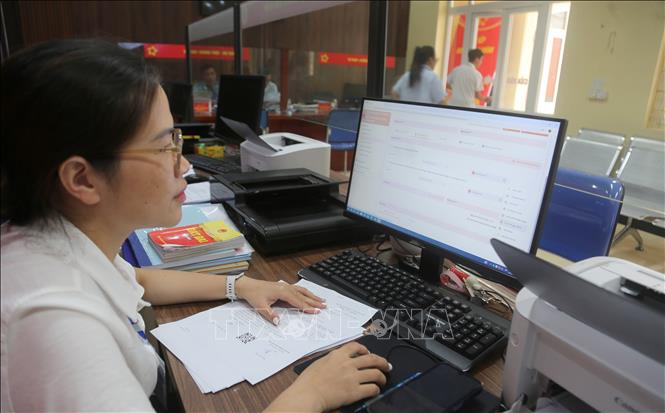 Chị Phạm Thị Toan, chuyên viên lĩnh vực đất đai, nông nghiệp, môi trường kiểm tra hồ sơ tiếp nhận của công dân trên Cổng dịch vụ công quốc gia. Ảnh: Minh Thu - TTXVN