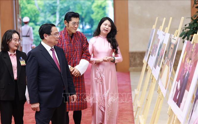 Thủ tướng Phạm Minh Chính và Quốc vương Bhutan Jigme Khesar Namgyel Wangchuck tham quan trưng bày ảnh về quan hệ hợp tác giữa hai nước do Thông tấn xã Việt Nam thực hiện. Ảnh: Dương Giang – TTXVN
