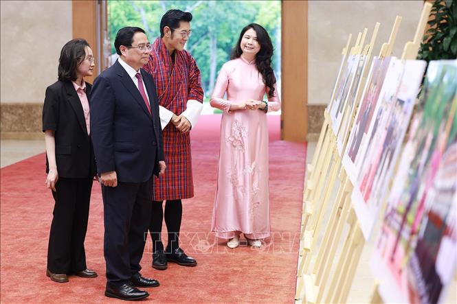 Thủ tướng Phạm Minh Chính và Quốc vương Bhutan Jigme Khesar Namgyel Wangchuck tham quan trưng bày ảnh về quan hệ hợp tác giữa hai nước do Thông tấn xã Việt Nam thực hiện. Ảnh: Dương Giang – TTXVN
