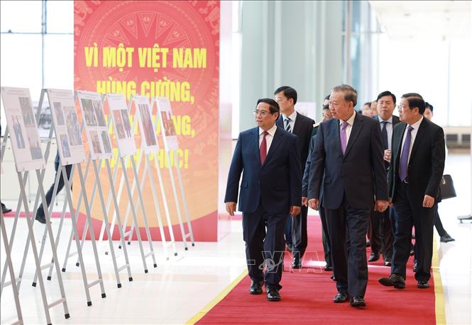 Tổng Bí thư Tô Lâm và Thủ tướng Phạm Minh Chính cùng các đại biểu tham quan trưng bày ảnh về hoạt động của Chính phủ qua các thời kỳ do Thông tấn xã Việt Nam thực hiện. Ảnh: Dương Giang-TTXVN

