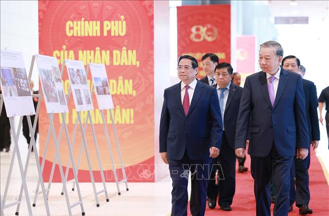 Tổng Bí thư Tô Lâm và Thủ tướng Phạm Minh Chính cùng các đại biểu tham quan trưng bày ảnh về hoạt động của Chính phủ qua các thời kỳ do Thông tấn xã Việt Nam thực hiện. Ảnh: Dương Giang-TTXVN
