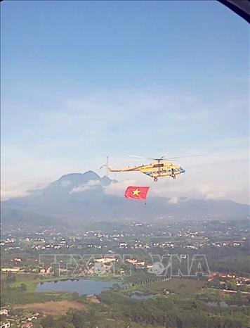 Máy bay trực thăng treo cờ bay huấn luyện ghép hình. Ảnh: TTXVN phát