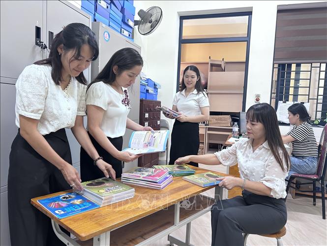 Chuẩn bị sách giáo khoa phục vụ năm học mới. Ảnh: Bích Huệ - TTXVN