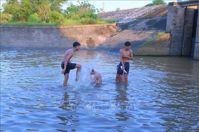 Thanh thiếu niên thản nhiên nô đùa dưới nước mà không có biện pháp an toàn, nguy hiểm có thể xảy ra bất kỳ khi nào. Ảnh: Công Luật - TTXVN
