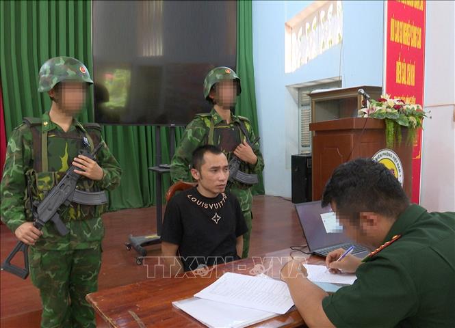 Lực lượng Bộ đội Biên phòng tỉnh Tây Ninh làm việc với Nguyễn Văn Sơn, người đang có lệnh truy nã của Công an tỉnh Bắc Ninh. Ảnh: TTXVN phát
