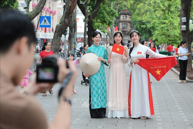 Người dân rạng rỡ chụp ảnh tại khu vực hồ Hoàn Kiếm. Ảnh: Lê Đông - TTXVN