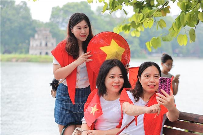 Người dân rạng rỡ chụp ảnh tại khu vực hồ Hoàn Kiếm. Ảnh: Lê Đông - TTXVN
