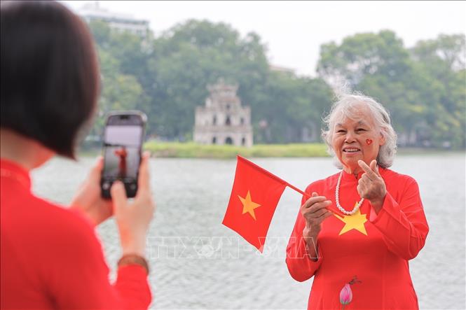 Người cao tuổi cũng hoà chung không khí, lưu lại khoảnh khắc đáng nhớ bên hồ Hoàn Kiếm. Ảnh: Lê Đông - TTXVN