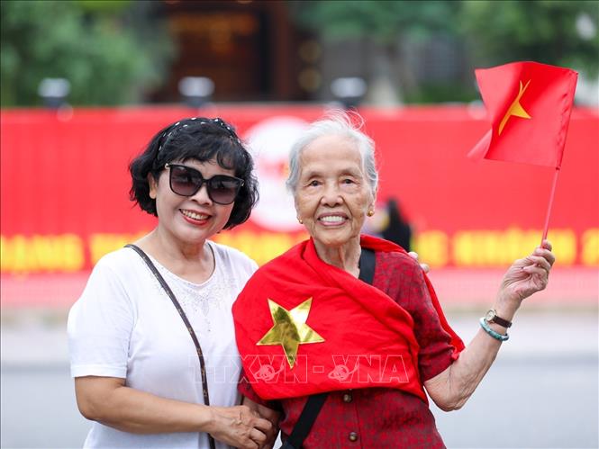 Trong những ngày gần đến Đại lễ, nhiều người dân xuống đường chụp ảnh với hình ảnh lá cờ Tổ quốc để thể hiện tình yêu nước và niềm tự hào dân tộc. Ảnh: Khánh Hoà - TTXVN