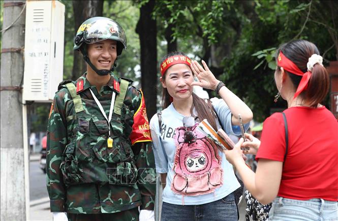 Người dân thích thú lưu giữ lại hình ảnh với những chiến sĩ Quân đội tham gia chốt trực tại các tuyến phố. Ảnh: Phạm Kiên - TTXVN