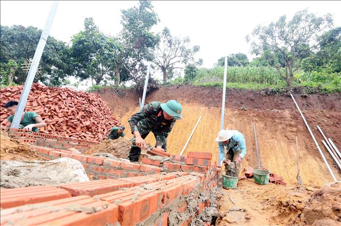 Các lực lượng tích cực tham gia xây dựng nhà ở cho nhân dân bị ảnh hưởng, thiệt hại do lũ quét, sạt lở đất trên địa bàn xã Huổi Một. Ảnh: Quang Quyết - TTXVN