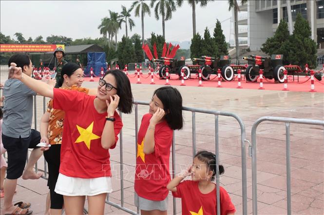 Người dân Thủ đô tranh thủ ghi lại kỷ niệm với dàn pháo lễ. Ảnh: Trần Thanh Giang - TTXVN