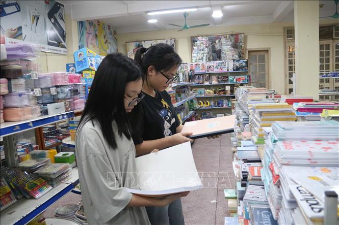 Học sinh lựa chọn sách vở và đồ dùng học tập chuẩn bị cho năm học mới. Ảnh: Thu Hoài - TTXVN