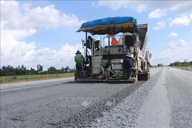 Công nhân thi công trên cao tốc Cần Thơ - Cà Mau.  Ảnh: Tuấn Phi - TTXVN