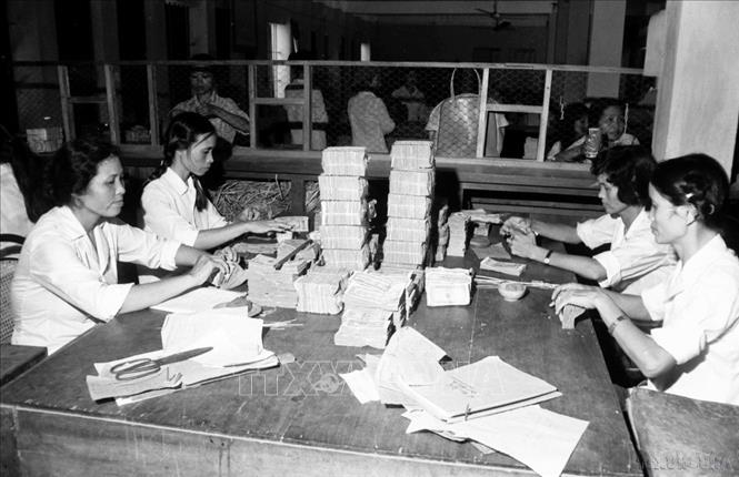 Trước năm 1986, nền kinh tế Việt Nam là nền kinh tế có hai hình thức sở hữu, hai loại hình kinh tế chủ yếu là xí nghiệp quốc doanh và tập thể. Trong ảnh: Ngân hàng Hải Hưng chuẩn bị tiền mặt, phục vụ bù giá vào lương (1985). Ảnh: Anh Tôn - TTXVN
