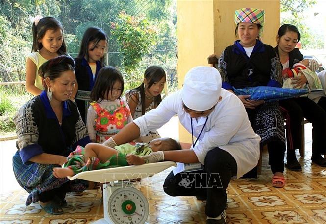 Từ chỗ thiếu đói triền miên, Việt Nam nhanh chóng trở thành nước xuất khẩu gạo hàng đầu thế giới. Nông dân no bụng, hàng triệu hộ gia đình có của ăn của để, hàng hóa dồi dào, kinh tế tiểu thương hồi sinh - tất cả đều bắt nguồn từ bước ngoặt 1986. Trong ảnh: Nhân viên y tế xã Hồ Bốn, huyện Mù Căng Chải kiểm tra sức khỏe cho trẻ. Ảnh: Dương Ngọc – TTXVN