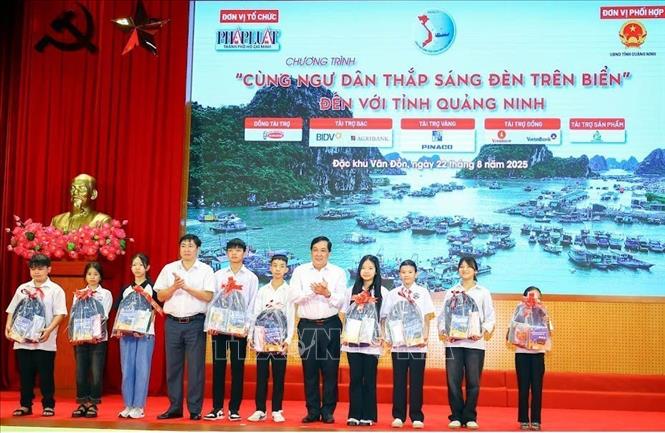 Ban tổ chức trao quà cho con em ngư dân có hoàn cảnh khó khăn, vượt khó học giỏi. Ảnh: TTXVN phát