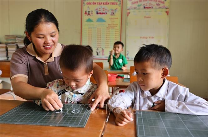 Giáo viên, Đảng viên trẻ Sùng Thị Say trong một buổi dạy viết chữ cho học sinh lớp 1 ở địa phương chuẩn bị vào năm học mới. Ảnh: Minh Đức – TTXVN