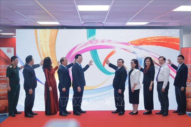 Phó Thủ tướng Mai Văn Chính và đại biểu thực hiện nghi thức khai trương Trung tâm báo chí triển lãm. Ảnh: Minh Quyết - TTXVN
