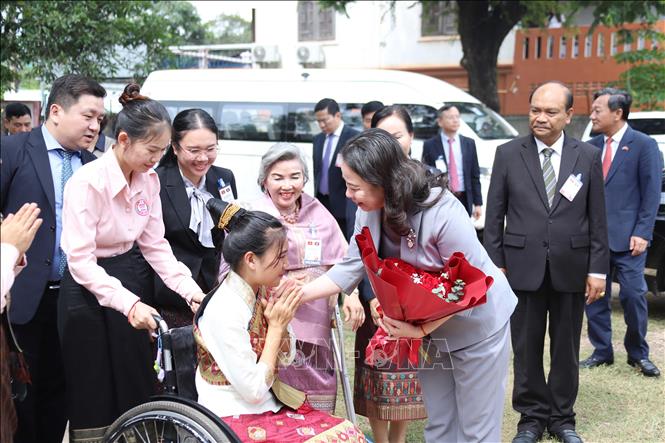 Phó Chủ tịch nước Võ Thị Ánh Xuân nhận hoa chúc mừng của Trung tâm dạy nghề phụ nữ khuyết tật thủ đô Viêng Chăn. Ảnh: Xuân Tú - PV TTXVN tại Lào