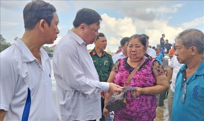 Chủ tịch UBND tỉnh Phạm Thành Ngại trực tiếp trao hỗ trợ bước đầu cho các hộ dân. Ảnh: Huỳnh Anh - TTXVN