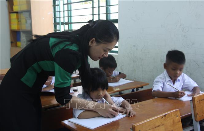 Cô giáo Võ Thị Minh Thư, Trường Tiểu học Phước Thắng, xã Bác Ái, tỉnh Khánh Hòa cầm tay rèn chữ cho trẻ chuẩn bị bước vào lớp 1. Ảnh: Phan Sáu - TTXVN