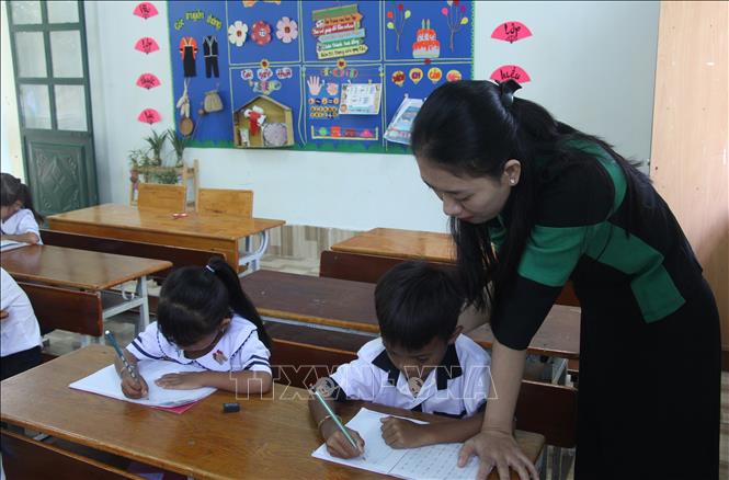 Cô giáo Võ Thị Minh Thư, xã Bác Ái, tỉnh Khánh Hòa cùng trẻ em luyện chữ tiếng Việt trước khi bước vào lớp 1. Ảnh: Phan Sáu - TTXVN