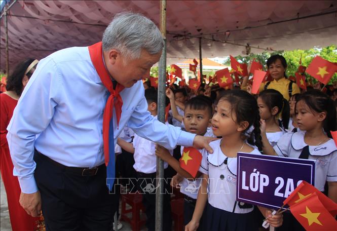 Phó Thủ tướng Thường trực Nguyễn Hòa Bình thăm hỏi tình hình học tập của học sinh Trường Tiểu học Nguyễn Lựu. Ảnh: Phan Sáu - TTXVN