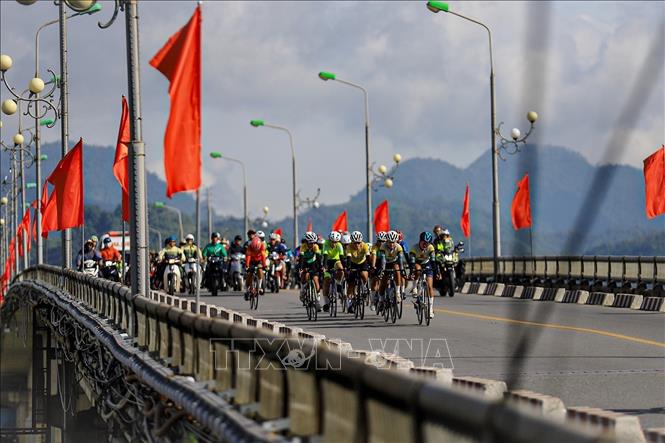 Đoàn đua thi đấu nội dung xuất phát đồng hàng 60km cá nhân và đồng đội qua cầu Hòa Bình 1. Ảnh: Trọng Đạt-TTXVN