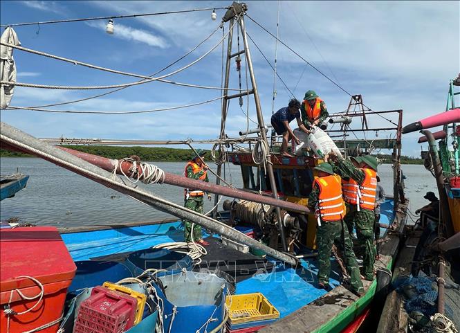 Border guards assist local fishemen in Nghe An province to anchor their vessels. VNA/Photo by courtesy