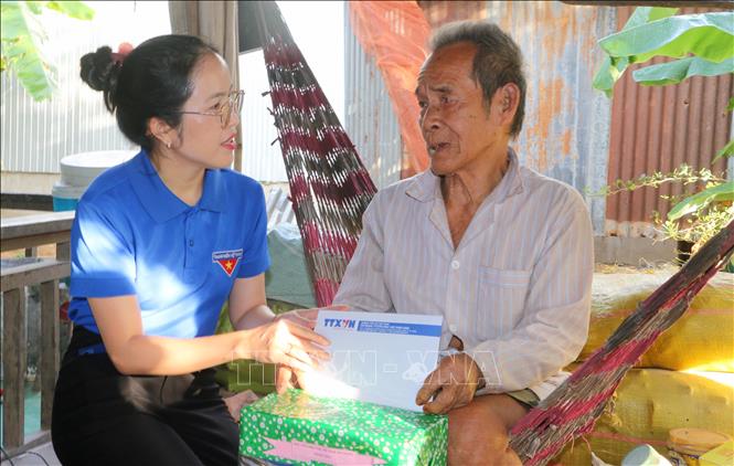 Phó Bí thư Đoàn thanh niên Trung tâm Thông tin Thông tấn xã Việt Nam khu vực phía Nam Bùi Thị Xuân Anh thăm, tặng quà gia đình có hoàn cảnh khó khăn tại xã Nhơn Hội, tỉnh An Giang. Ảnh: Công Mạo-TTXVN