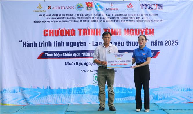 Phó Bí thư Đoàn thanh niên Trung tâm Thông tin Thông tấn xã Việt Nam khu vực phía Nam Bùi Thị Xuân Anh trao bảng tượng trưng trao tặng 10 xe đạp, 20 suất học bổng cho học sinh có hoàn cảnh khó khăn, nỗ lực vươn lên học tốt trên địa bàn xa Nhơn Hội, tỉnh An Giang. Ảnh: Công Mạo-TTXVN