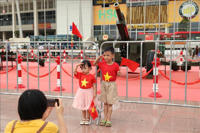 Nhiều em nhỏ háo hức tạo dáng để chụp ảnh bên dàn pháo lễ. Ảnh: Vũ Quang - TTXVN