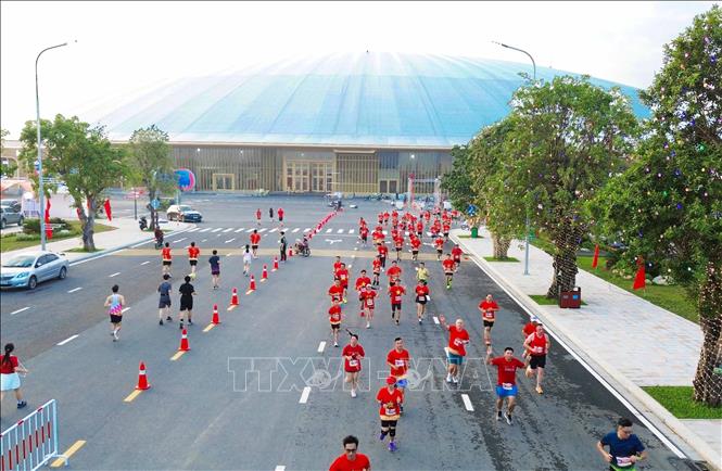 Các vận động viên chạy qua khu vực trung tâm Triển lãm Quốc gia. Ảnh: Thành Phương - TTXVN