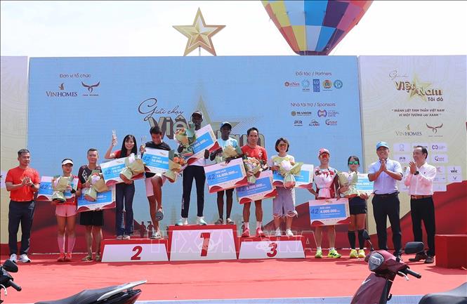 Ban tổ chức trao huy chương cho các vận động viên ở cự ly 42km. Ảnh: Thành Phương – TTXVN