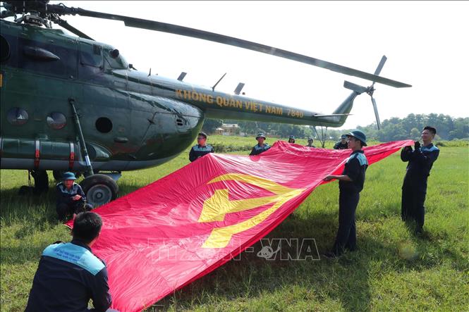Biên đội máy bay trực thăng của Quân chủng Phòng không - Không quân thực hiện công việc treo cờ Đảng và cờ Tổ quốc trước khi bay vào trung tâm Thủ đô Hà Nội. Ảnh: Trọng Đức - TTXVN