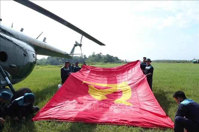 Biên đội máy bay trực thăng của Quân chủng Phòng không - Không quân thực hiện công việc treo cờ Đảng và cờ Tổ quốc trước khi bay vào trung tâm Thủ đô Hà Nội. Ảnh: Trọng Đức - TTXVN