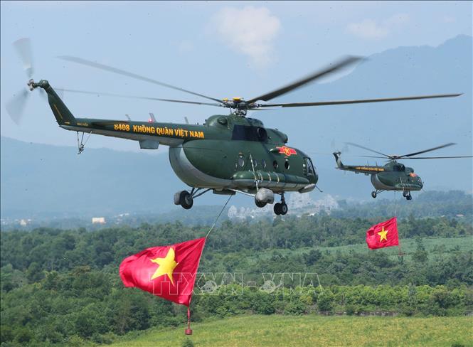 Biên đội máy bay trực thăng của Quân chủng Phòng không - Không quân treo cờ Đảng và cờ Tổ quốc bay vào trung tâm Thủ đô Hà Nội. Ảnh: Trọng Đức - TTXVN