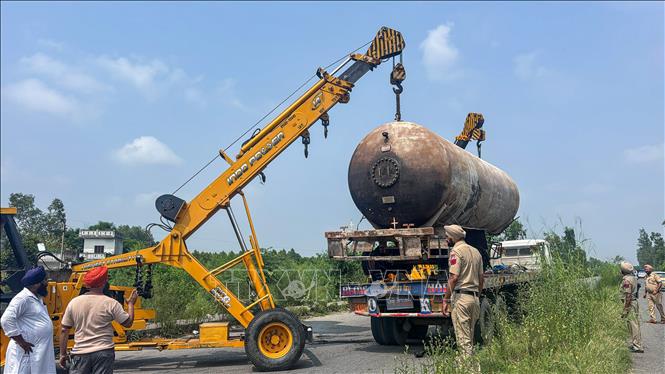 Cảnh sát và lực lượng cứu hộ di chuyển bồn chứa khí đốt hóa lỏng (LPG) sau vụ tai nạn giao thông khiến xe bồn phát nổ tại huyện Hoshiarpur, bang Punjab, Pakistan ngày 23/8/2025. Ảnh: ANI/TTXVN