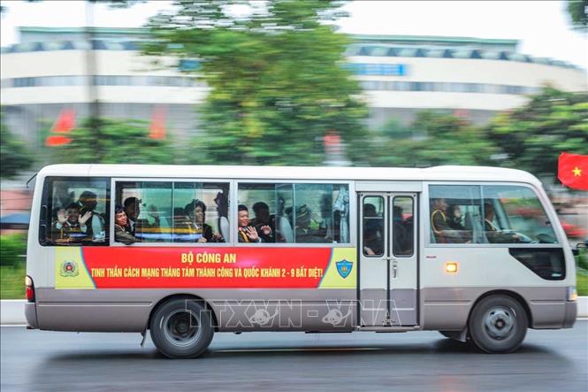 Các lực lượng tham gia hợp luyện diễu binh, diễu hành của Bộ Công an vẫy tay chào người dân khi di chuyển qua đường Văn Cao đến địa điểm tập kết (ảnh chụp lúc 14h) Ảnh: Hoàng Hiếu - TTXVN