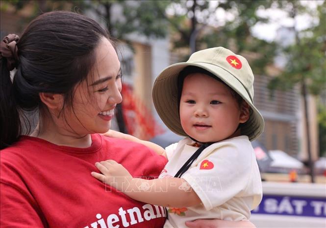 Cùng mẹ đi xem tổng hợp luyện diễu binh, diễu hành cho Đại lễ A80. Ảnh: Văn Điệp - TTXVN