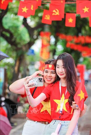 Người dân lưu lại kỷ niệm trước buổi hợp luyện lần 2 của lễ diễu binh, diễu hành. Ảnh: Hoàng Hiếu - TTXVN