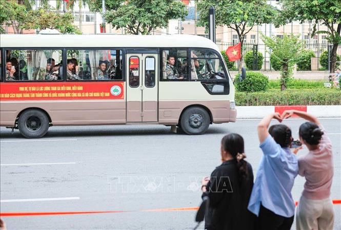 Người dân chào đón xe chở đoàn diễu binh, diễu hành đi qua phố Văn Cao (ảnh chụp lúc 15h40'). Ảnh: Hoàng Hiếu - TTXVN