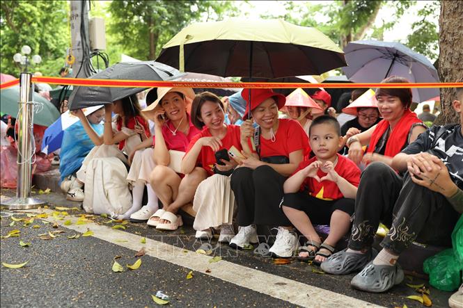 Người dân kiên nhẫn ngồi chờ đợi dưới mưa để chứng kiến buổi Tổng hợp luyện diễu binh, diễu hành lần 2. Ảnh: Vũ Quang – TTXVN