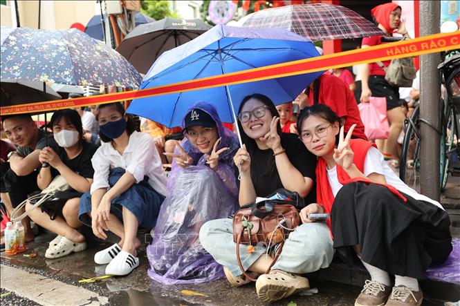 Các bạn trẻ tạo dáng chụp ảnh lưu niệm trong khi chờ đợi theo dõi Tổng hợp luyện diễu binh, diễu hành lần 2. Ảnh: Vũ Quang – TTXVN