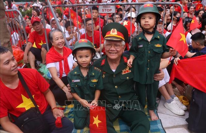 Ông cháu cùng chờ xem buổi tổng hợp luyện diễu binh, diễu hành A80 lần thứ 2. Ảnh: Văn Điệp - TTXVN